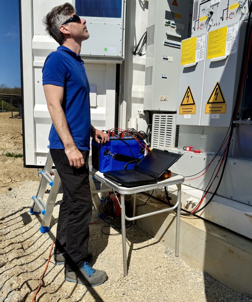Schutzprüfer von Rauwolf Etec GmbH prüft ein wandlerstromversorgtes Schutzrelais in einem PV-Park